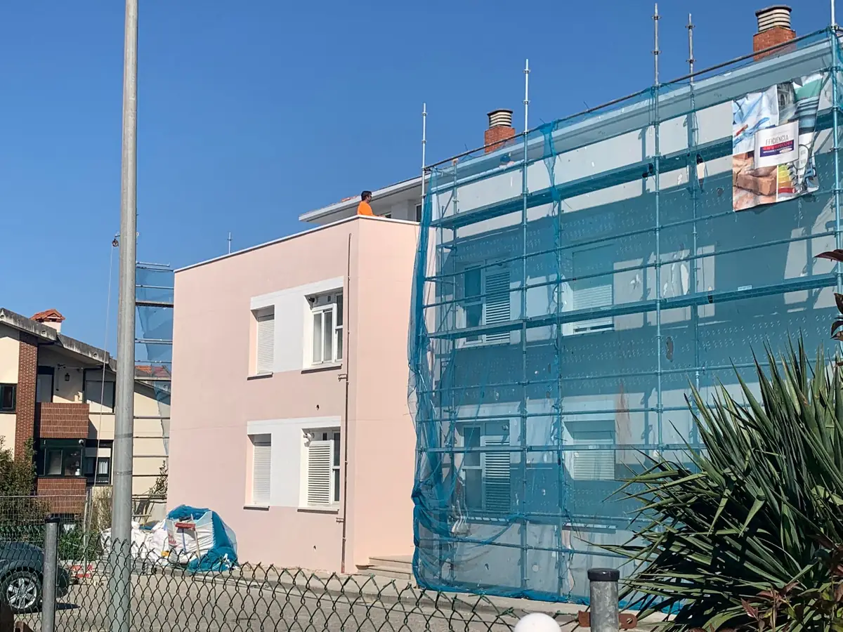 Edificio de viviendas con andamio mientras se aísla la fachada por el exterior